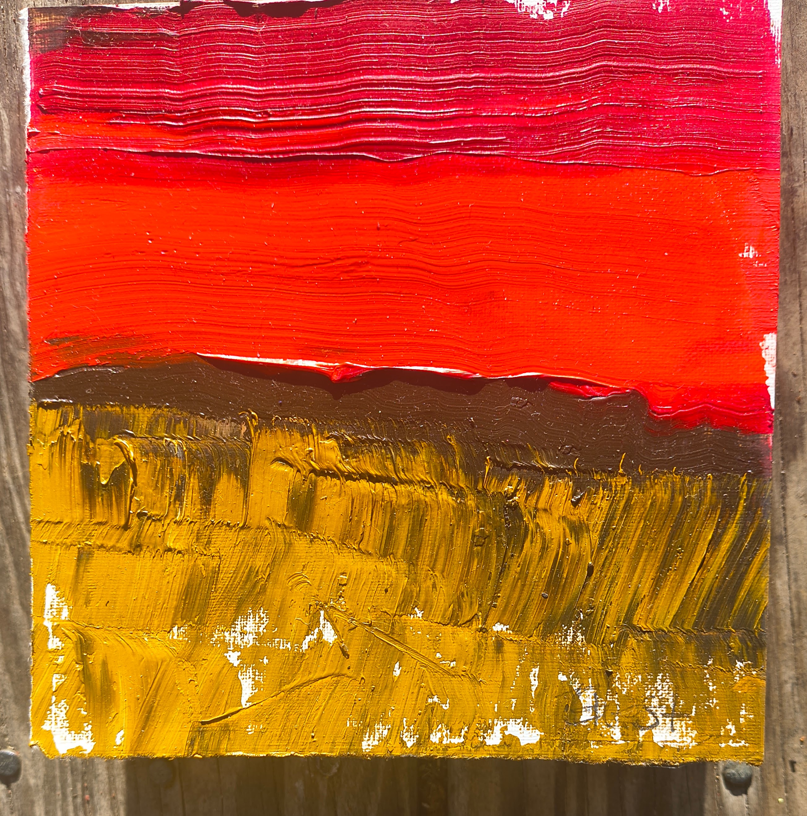 Oil on paper mounted on a box depicting a landscape in warm earth tones and red.